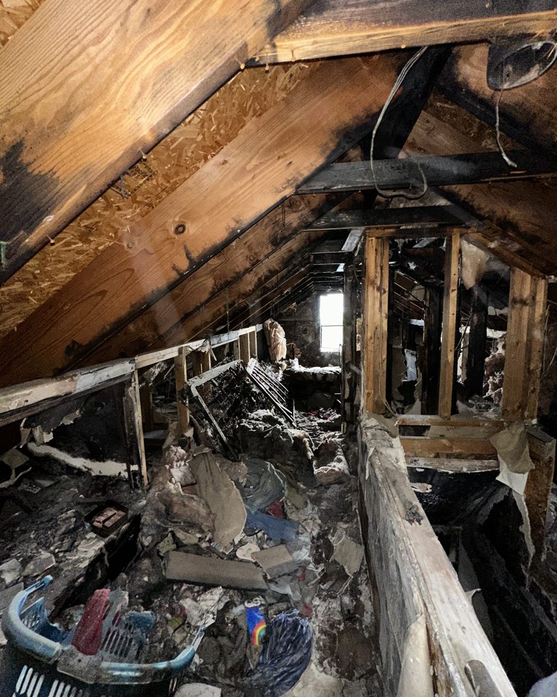 The same house: the upstairs, before: burned rafters and fire debris