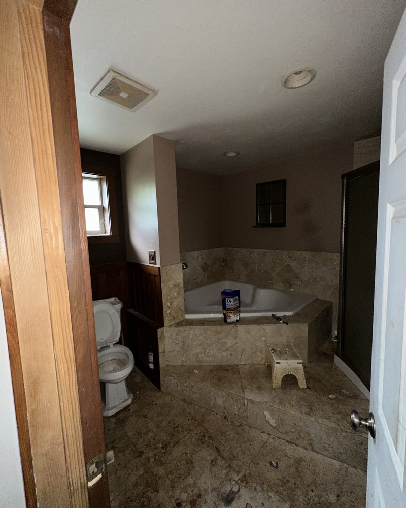 The same house: the main bathroom, before: stained tile and a dirty tub